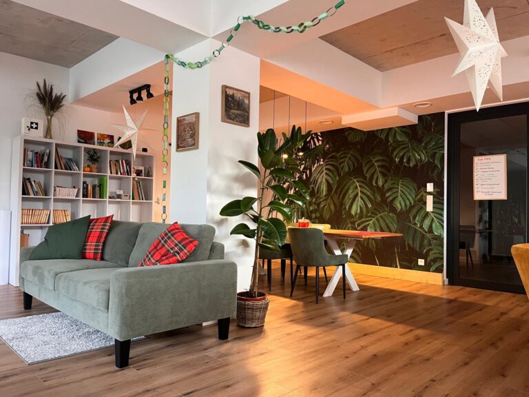 Przestronny salon z roślinami i strefą wypoczynku – Seniorlandia dom opieki przyjazne wnętrza dla seniorów