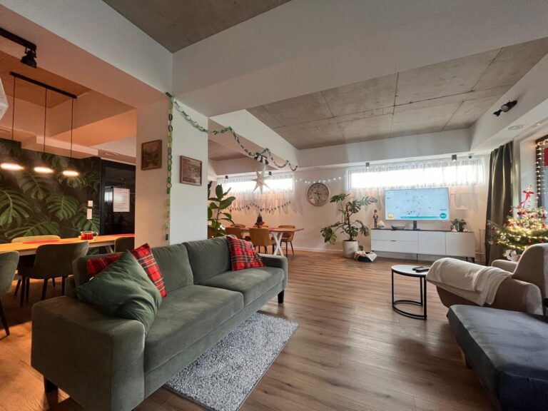 Wspólna przestrzeń dzienna z sofami i stołem – Seniorlandia dom opieki integracja mieszkańców